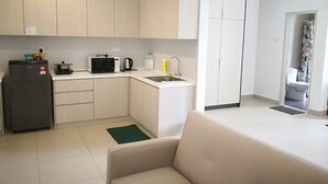 A compact kitchen with a refrigerator, microwave, kettle, and sink. - ETM Midhills Holiday Studio (Genting Highlands)