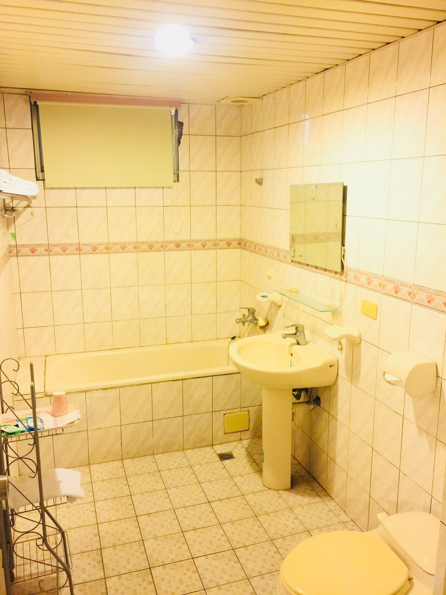 A bathroom with a bathtub, sink, mirror, toilet, and a towel rack.