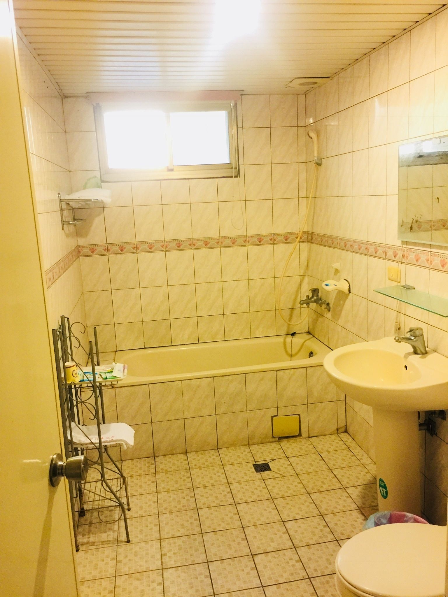 Een compacte badkamer met een bad, een wastafel en een toilet.