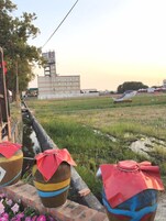 Un canal con barcos, un edificio al fondo y un campo cubierto de césped.