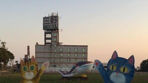 Two large cat statues in a grassy field with a building in the background. - San Ho Business Hotel (Xiluo)