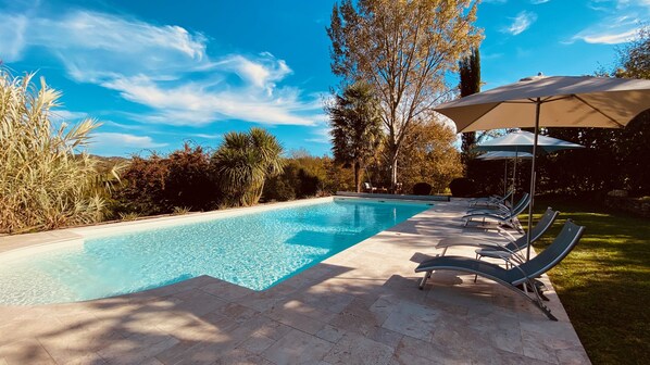 حمّام سباحة خارجي، مظلات على حمّام السباحة، مقاعد للتشمس