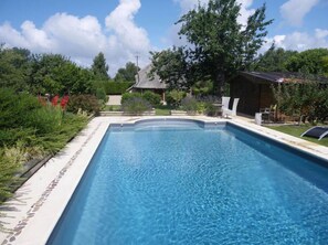 室外游泳池，池畔遮阳伞，日光浴躺椅