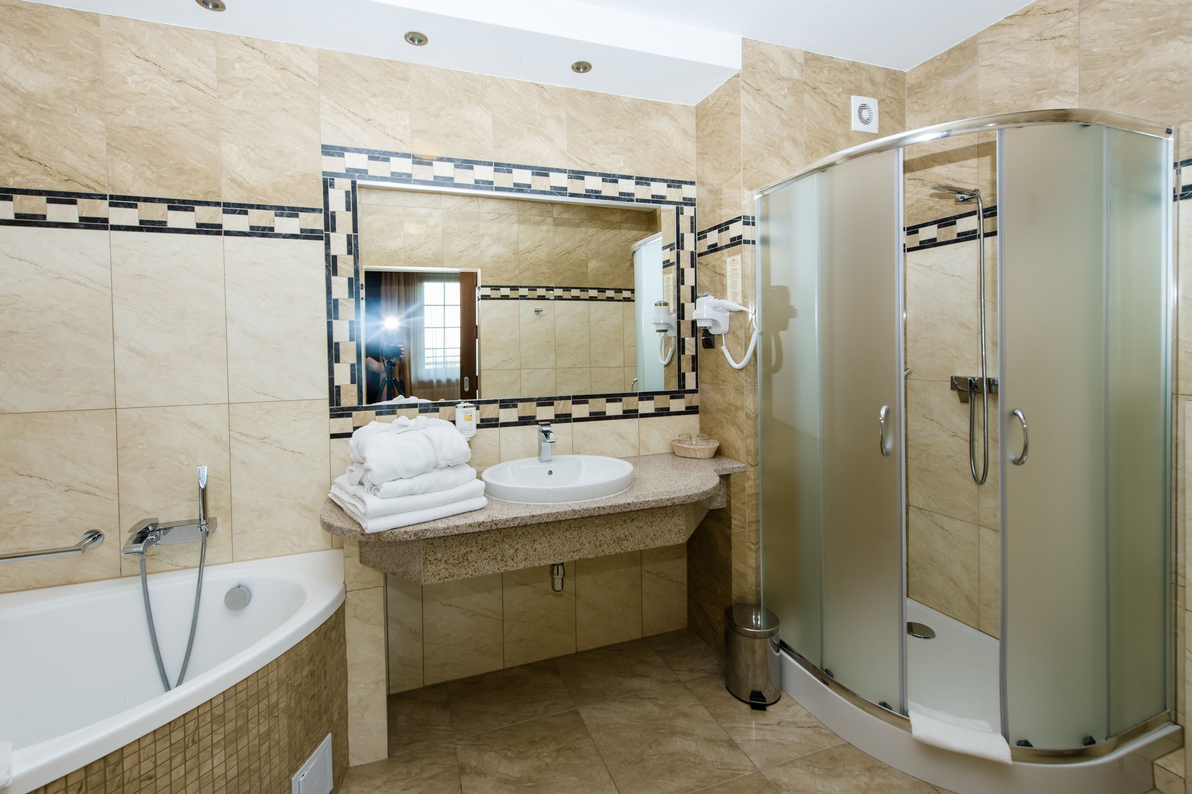 Un baño moderno con bañera, lavamanos y cabina de ducha con mampara de vidrio.