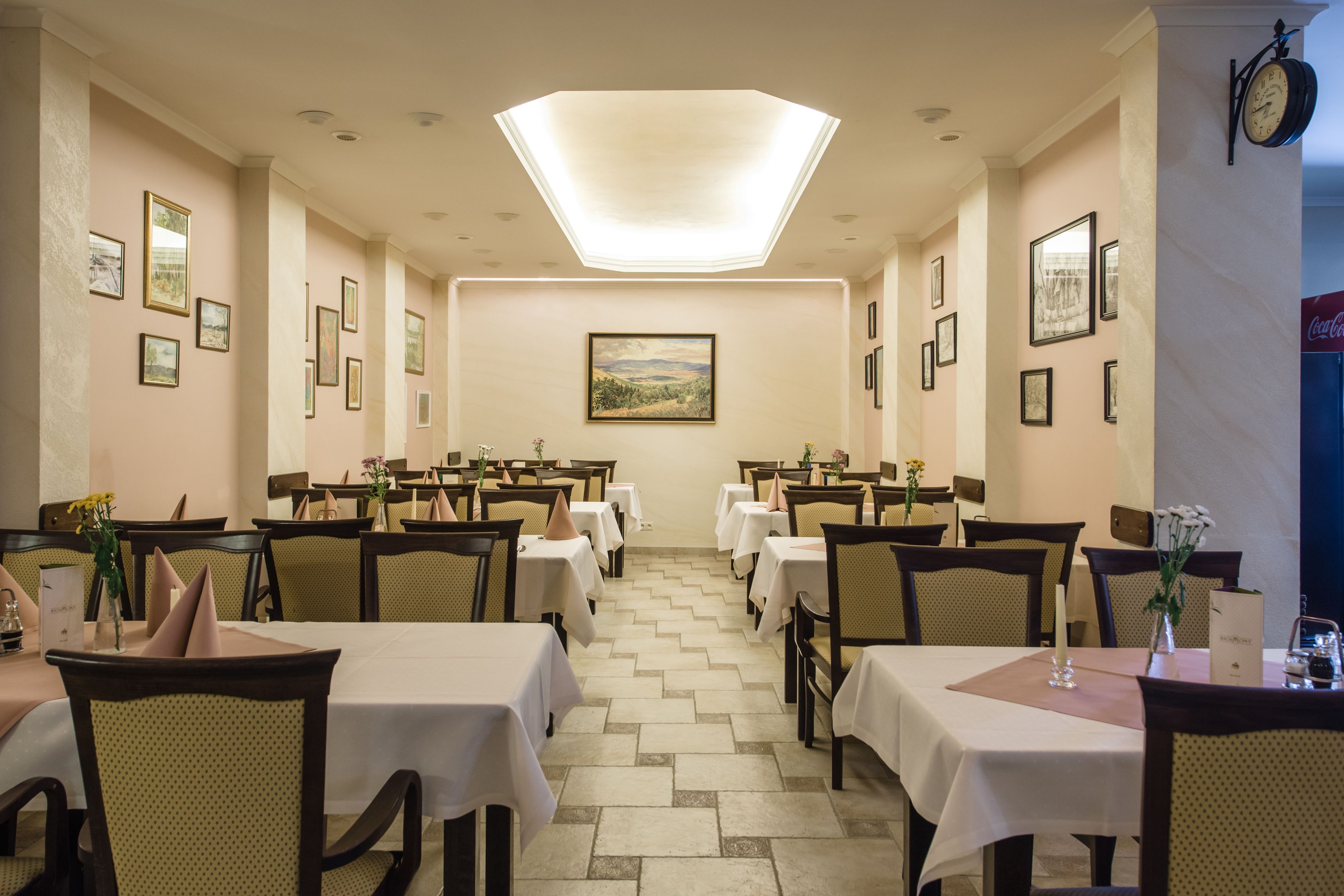 A dining area with multiple tables and chairs, arranged in a symmetrical layout.