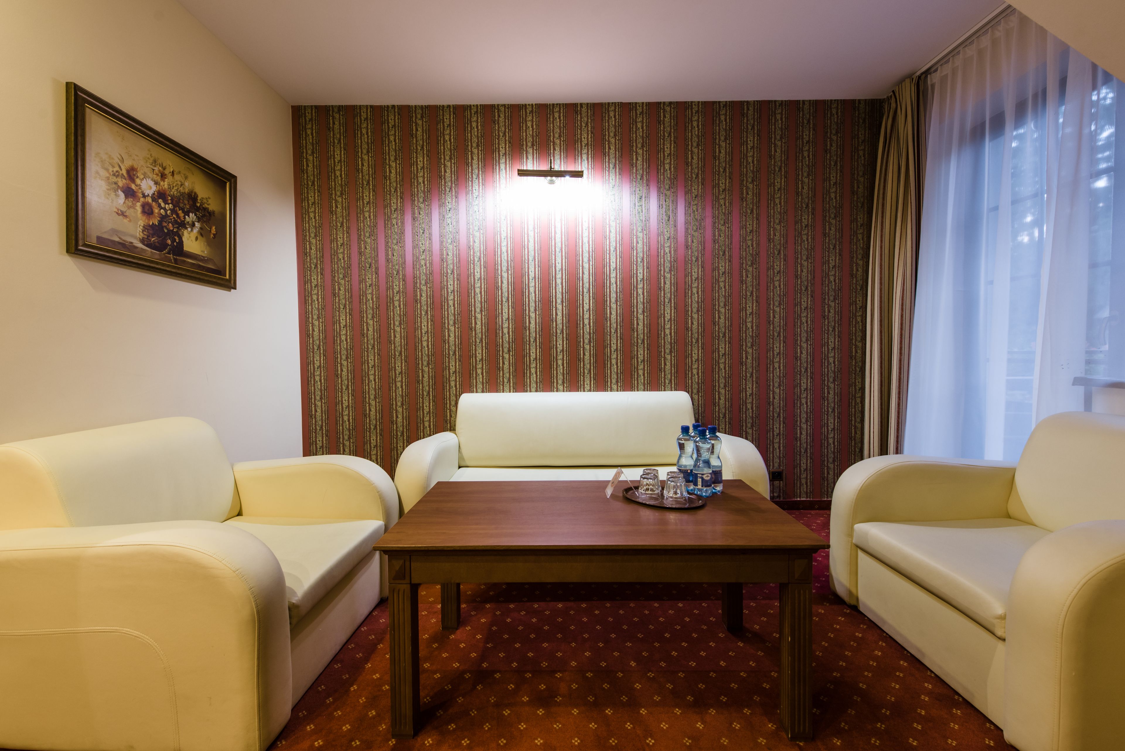 Una habitación con sofá, una mesita de centro y un papel tapiz estampado.
