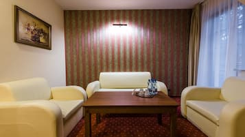 Una habitación con sofá, una mesita de centro y un papel tapiz estampado.