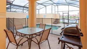 A covered outdoor area with a pool, a barbecue grill, and a table with chairs. - Fv46473 - Paradise Palms - 4 Bed 3 Baths Townhome (Kissimmee)