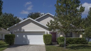 A single-story house with a garage, a front door, and a driveway. - Ip60179 - Silver Creek - 4 Bed 3 Baths Villa (Clermont)