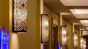 A hallway with decorative wall sconces and a blue-lit sign with the number 303. - Plus Hotel Setif (Setif)