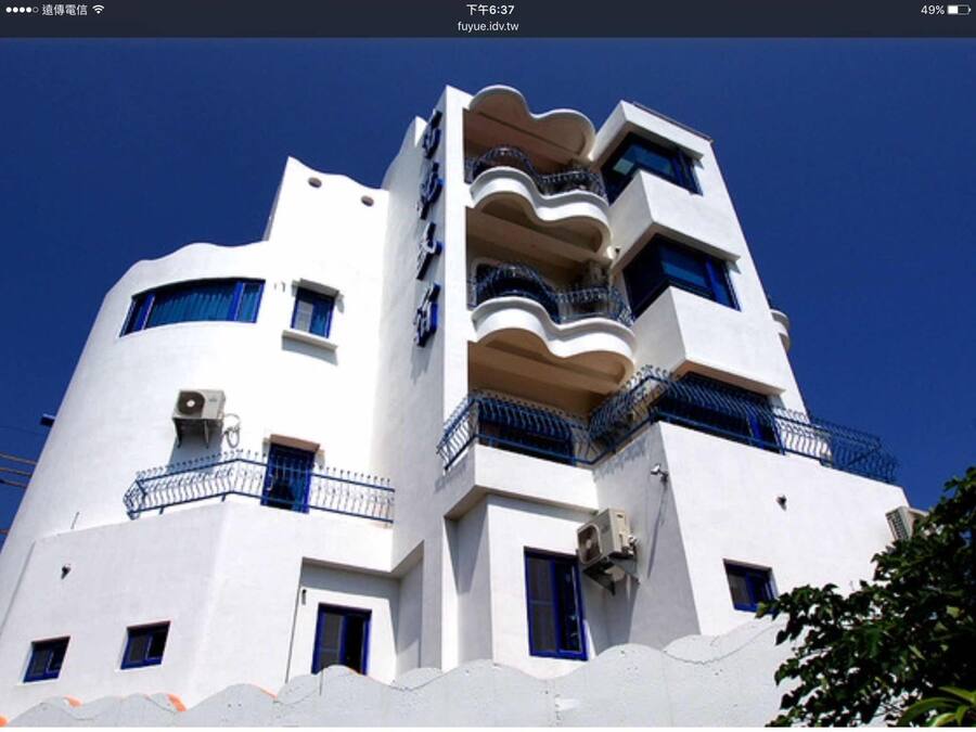Um edifício moderno com um design arquitetônico único, com varandas e várias janelas.