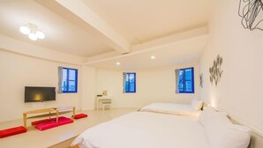 A modern hotel room with two beds, a flat-screen TV, a desk, and a chair. - Fuyue sea View (Taitung)