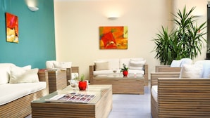 A modern living room with a sofa set, a coffee table, and a painting on the wall.