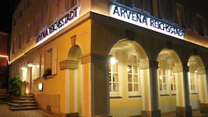 A building with the sign "ARVENA REICHSHOF" at the entrance, featuring a classic architectural style with arched windows and a brick facade.