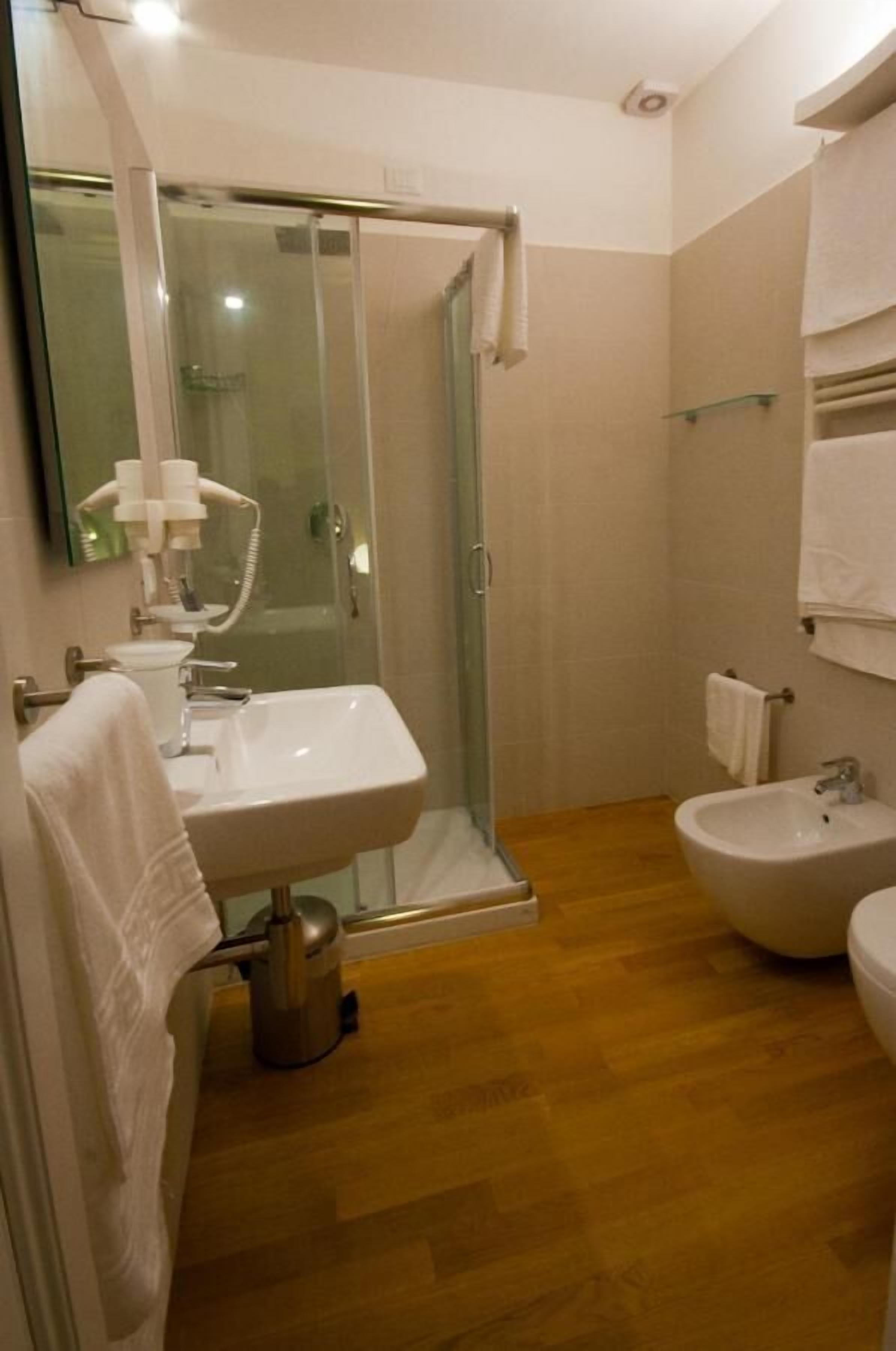 Ein Badezimmer mit Dusche, Waschbecken und Bidet.