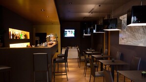 A restaurant with a bar area, wooden flooring, and modern lighting fixtures. - Hotel Muraglie (Vibo Valentia)