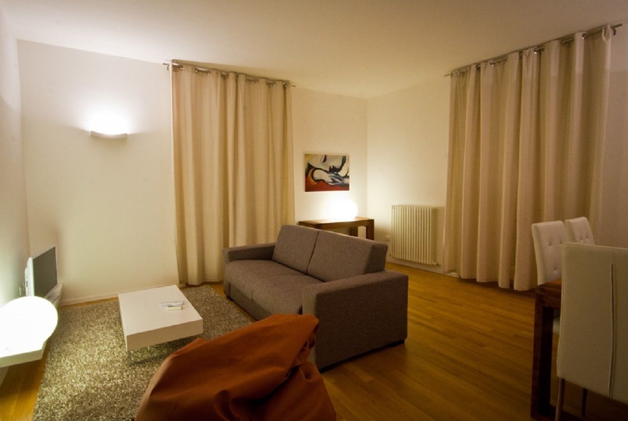 A living room with a sofa, a coffee table, a TV, and a lamp.