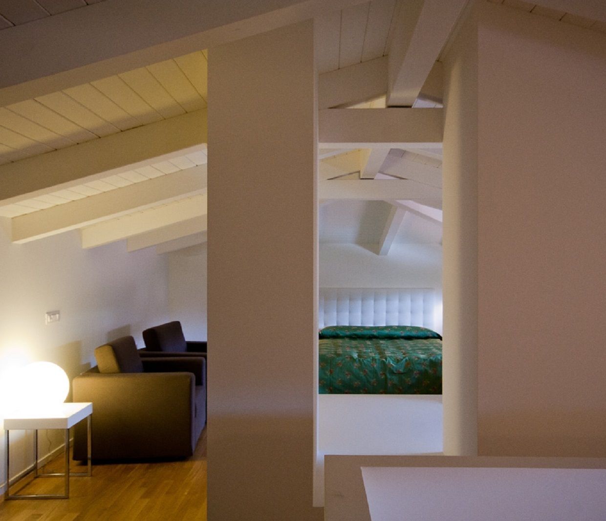A modern room with a bed, a desk, and a chair.
