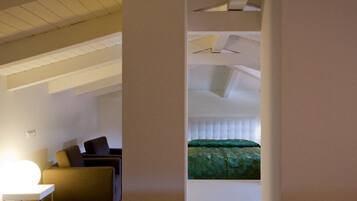 A modern room with a bed, a desk, and a chair.
