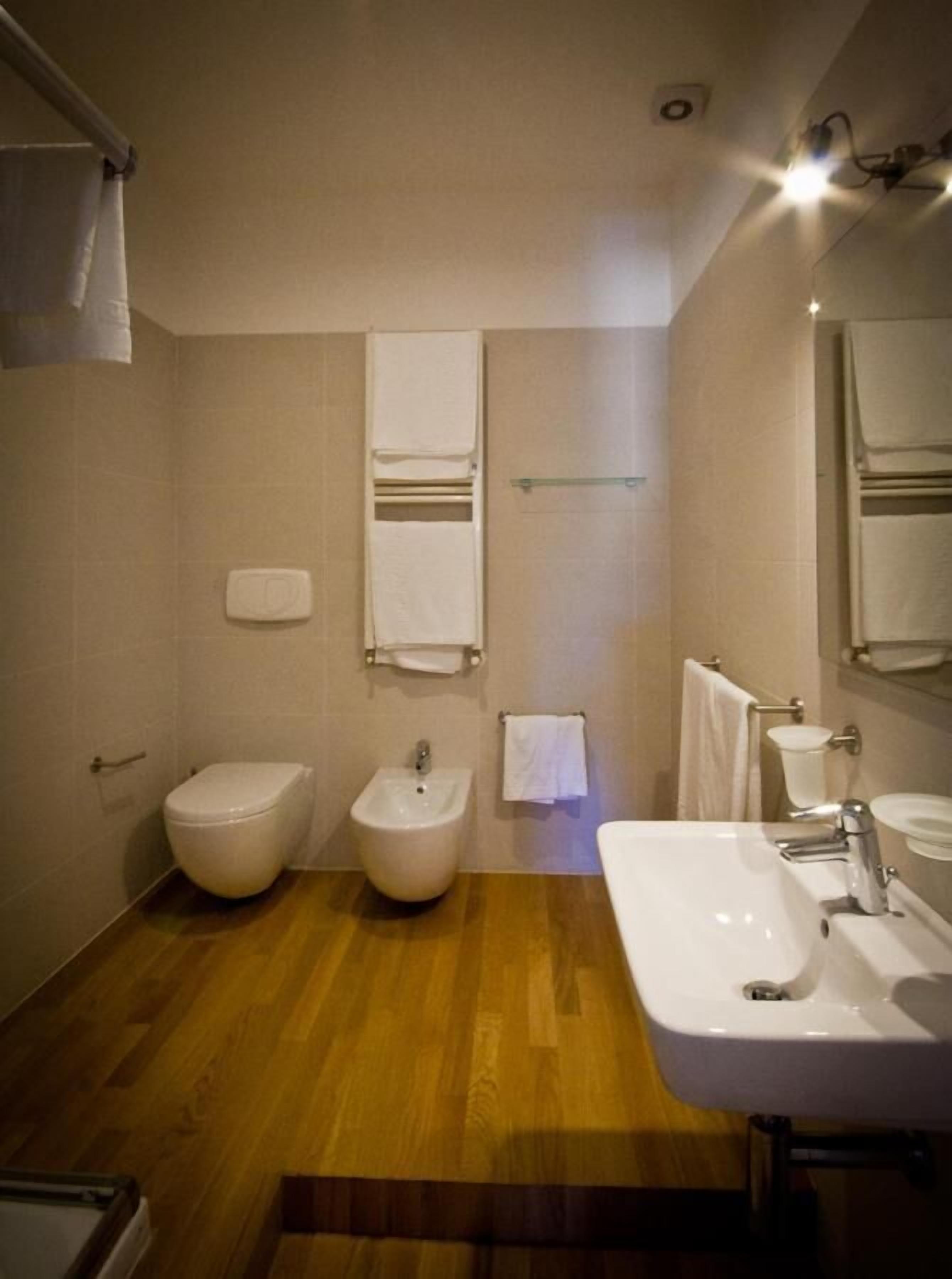 Un bagno con bidet, WC e lavandino.