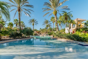 A pool surrounded by palm trees and a building with a sign indicating an emergency exit. - Ip60296 - Regal Palms Resort & Spa - 4 Bed 3 Baths Townhome (Davenport)