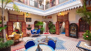 A courtyard with a central fountain, seating areas, and ornate doors. - Riad bleu du sud (Marrakech)