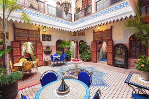 Um pátio com fonte, área de estar e detalhes decorativos.