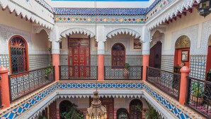 A multi-level courtyard with ornate arches, tiled floors, and a central lantern. - Riad bleu du sud (Marrakech)