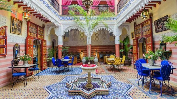 A courtyard with a fountain, seating areas, and ornate architecture. - Riad bleu du sud (Marrakech)