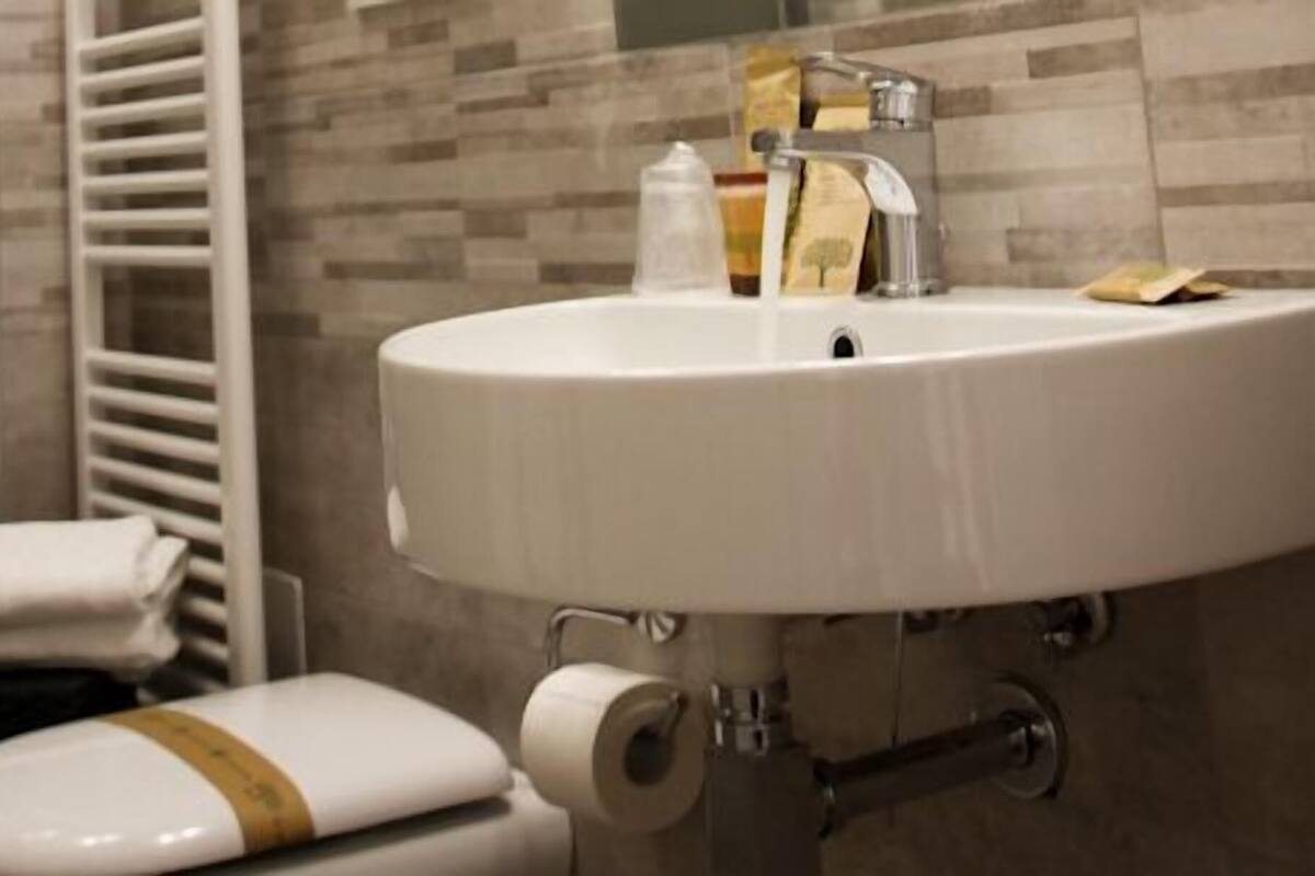 A bathroom with a white sink, toilet, and towel rack.