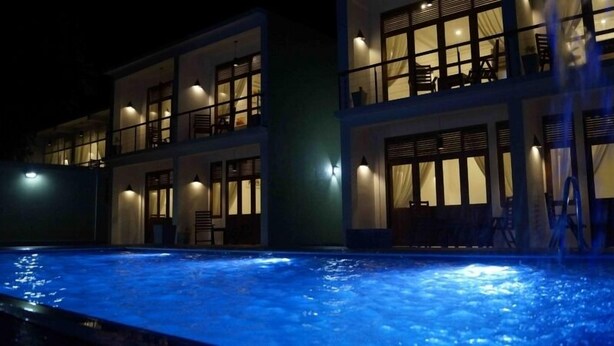 Un hotel de varios pisos con una piscina en primer plano.
