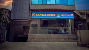A hotel with a modern design, featuring a large glass facade and a flag on top. - Kantel Hotel (Mandalay)