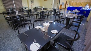 A dining area with multiple tables and chairs, arranged in a spacious layout. - Kantel Hotel (Mandalay)