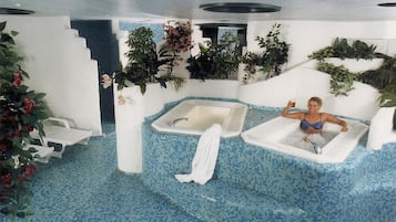 Relax by the pool surrounded by lush greenery and enjoy a refreshing dip in the mosaic-tiled pool.