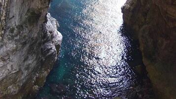 L'apertura naturale di una grotta con il mare blu intenso visibile attraverso l'ingresso.