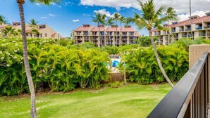 A resort with multiple buildings, lush greenery, and a clear sky.