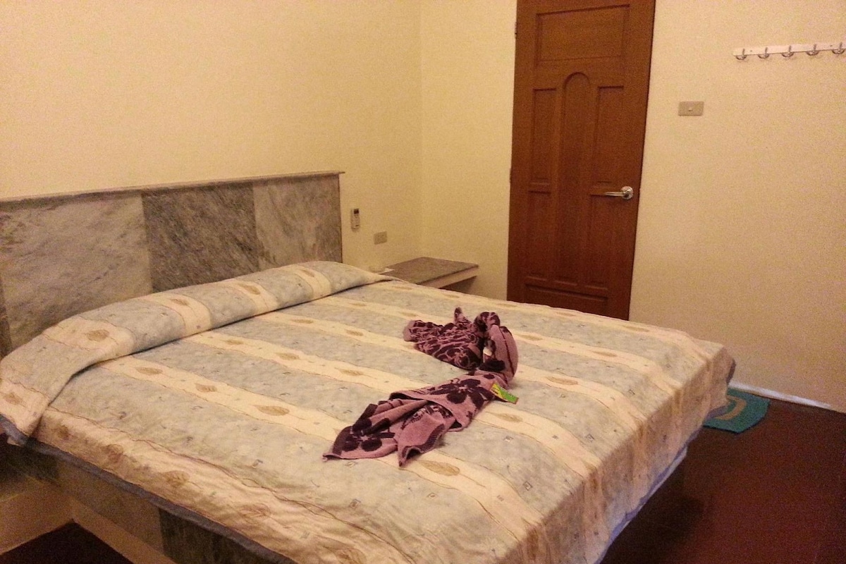 Un lit avec une couvre-lit à motifs et une couverture.