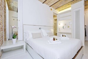 Una camera d'albergo moderna con un letto grande, un comodino con una pianta e un armadio a muro.