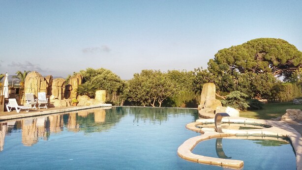 Ein Pool mit Liegestühlen und einer felsigen Landschaft.