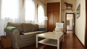Ein Wohnzimmer mit einer Couch, einem Couchtisch, einer Lampe und Holzboden.