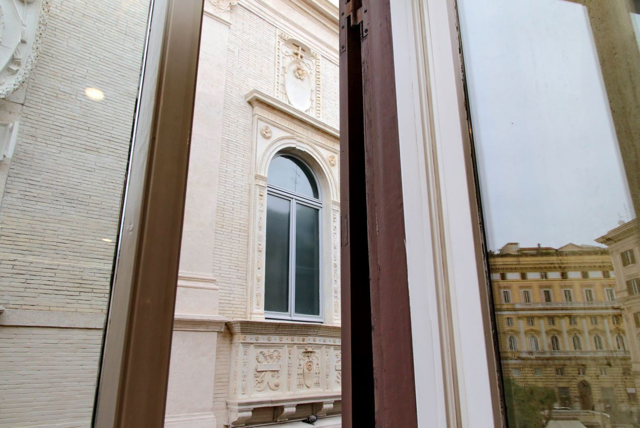 A building facade with a large arched window and detailed architectural carvings.