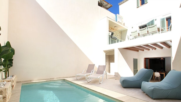 A pool area with lounge chairs, a table, and a staircase leading to an upper level. - Pius Eleven by Balearic Villas (Pollensa)