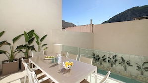 A dining area with a table, chairs, and potted plants. - Pius Eleven by Balearic Villas (Pollensa)