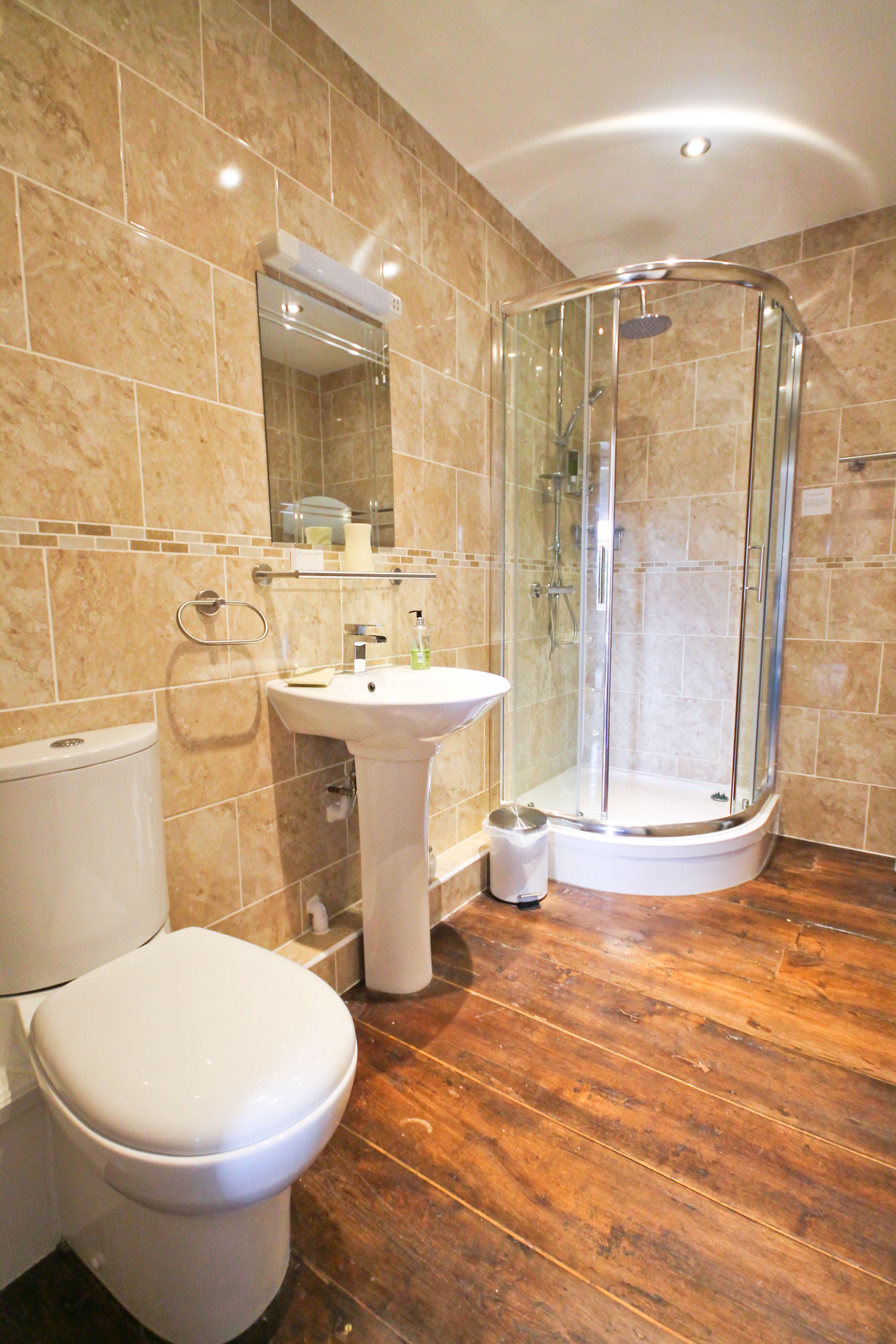 A bathroom with a toilet, sink, and glass-enclosed shower.