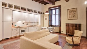 Une cuisine moderne avec des meubles blancs, une table à manger et un canapé.