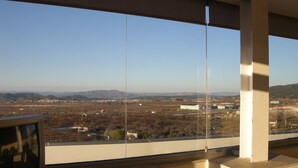 A room with a large window overlooking a landscape with mountains and buildings. - Hotel SG Bullas (Bullas)