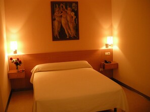 A hotel room with a large bed, two bedside tables, a nightstand with a vase of flowers, and a painting on the wall. - Hotel SG Bullas (Bullas)