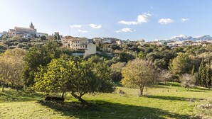 Une ville située sur une colline, avec des bâtiments, une église imposante et une montagne en arrière-plan.