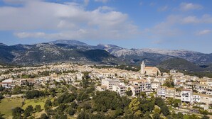 Une ville qui se distingue par son église imposante et par les montagnes qui se dressent à l'arrière-plan.