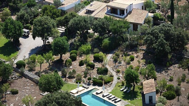 Un quartier résidentiel comprenant plusieurs maisons, une piscine et un petit pavillon d’invités.